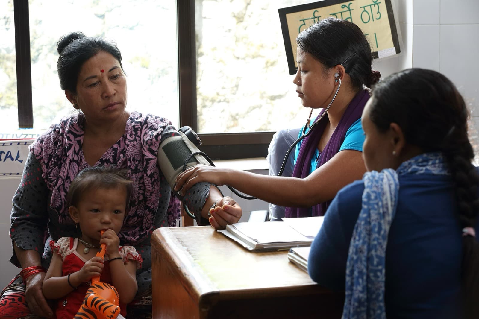 A health worker checks a patient's blood pressure in Pokhara